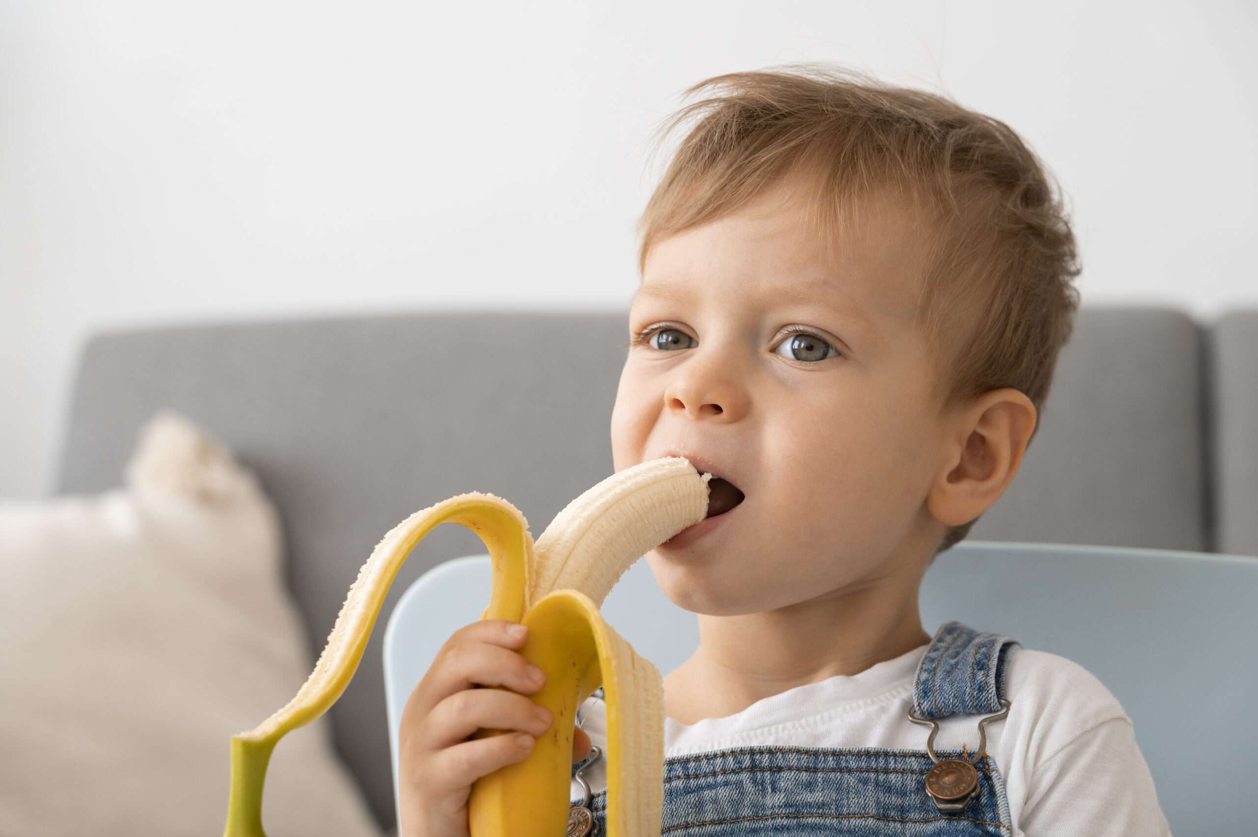 young-boy-eating-banana-home Bacho Ke Dast Ka Ilaj
