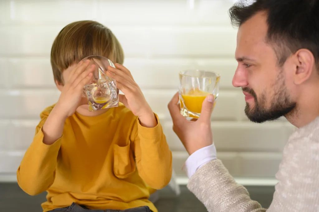 Parent helping with Heat Stroke Symptoms for Kids by giving water