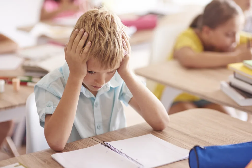 A child feeling stressed in classroom — How Can Parents Support a Child with Migraines.