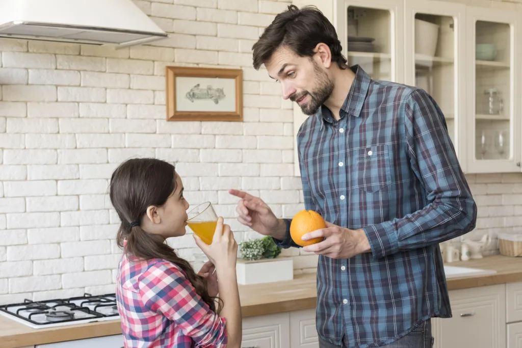 Father teaching his daughter about healthy fruits and vitamins – promoting natural remedies for allergies in kids through nutrition.